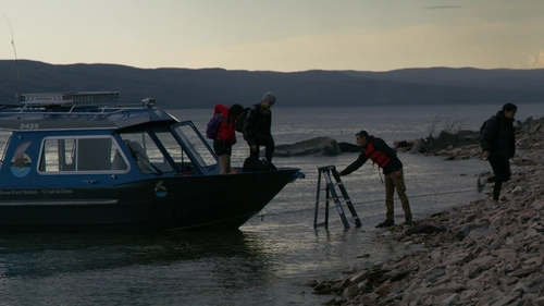 People exit the boat onto the shore